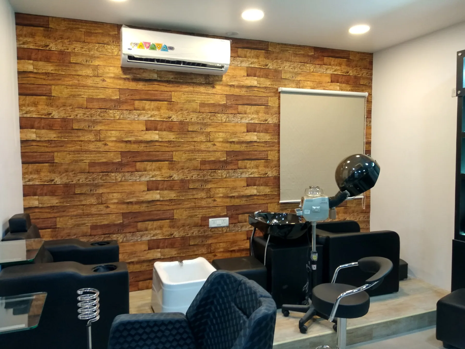 Salon wash basins and styling chairs beside a timber-clad wall