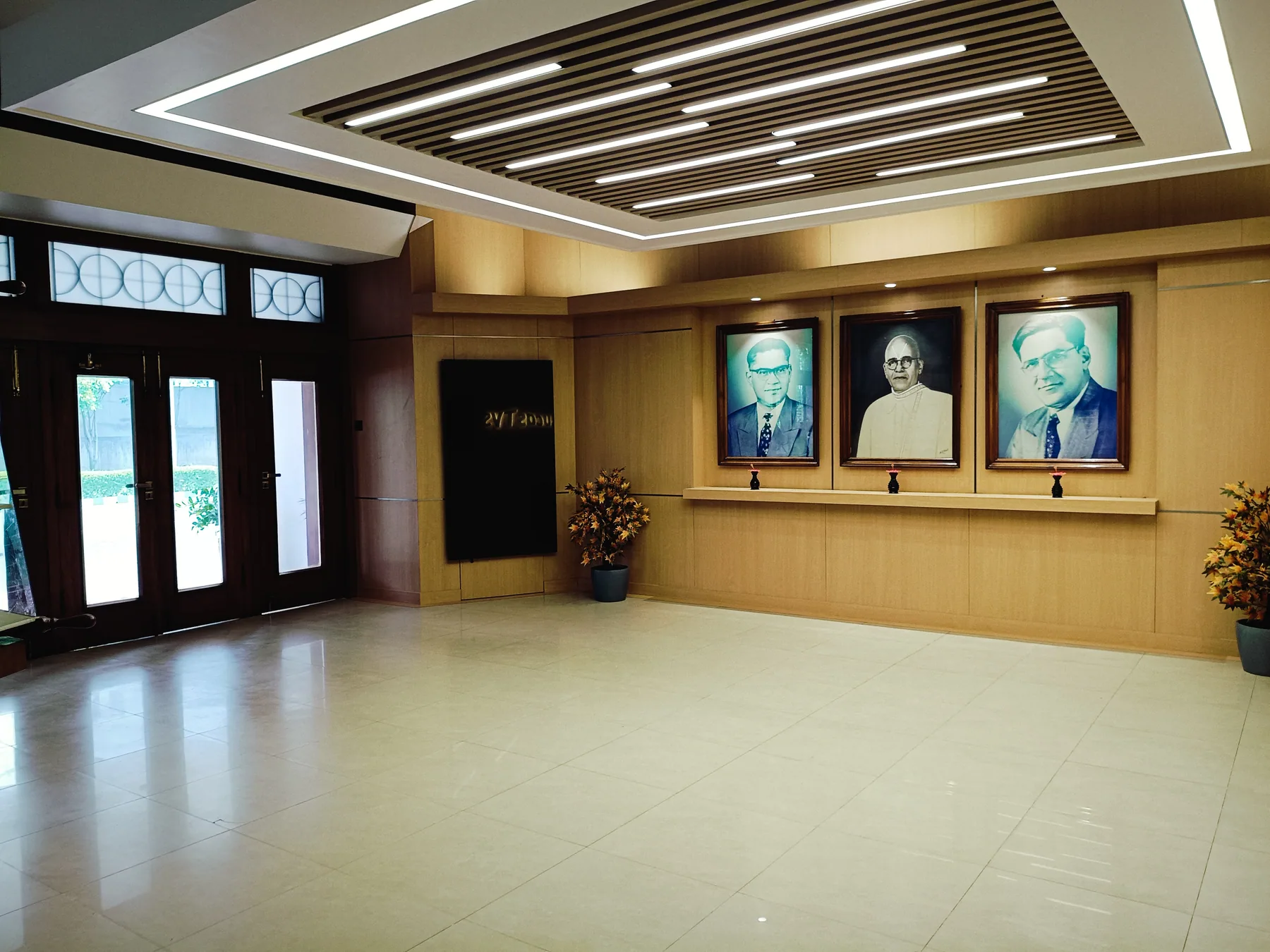 Wide lobby view with entrance doors and portrait display