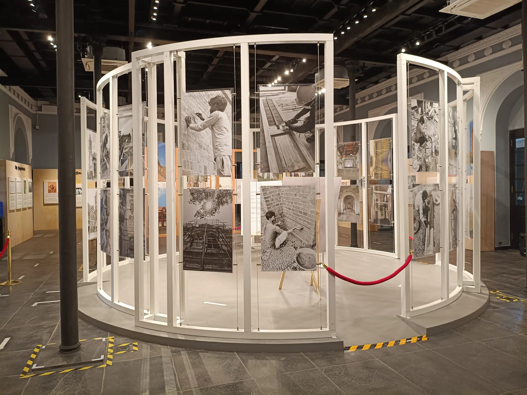 Circular white display structure with suspended historical images